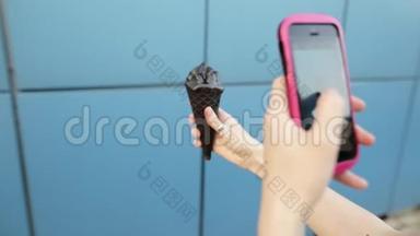 现代女孩在智能手机上拍冰淇淋。 有选择的焦点。